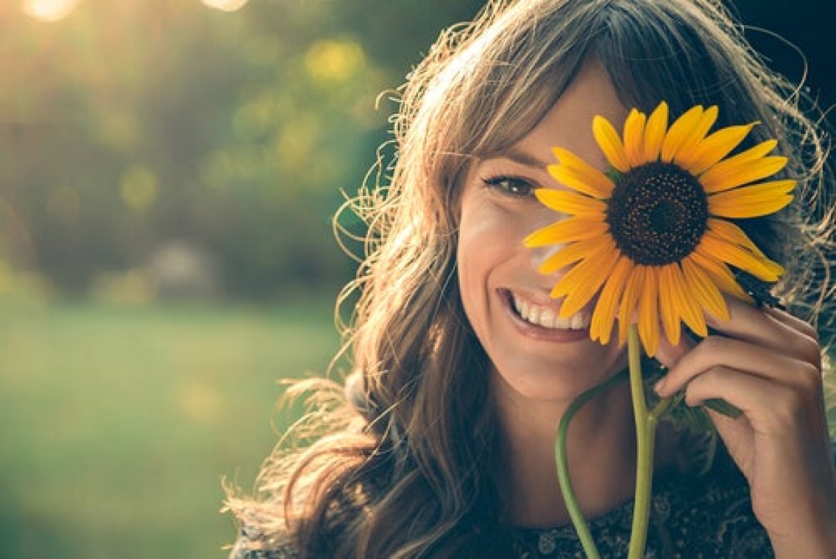 woman-smiling-with-sunflower